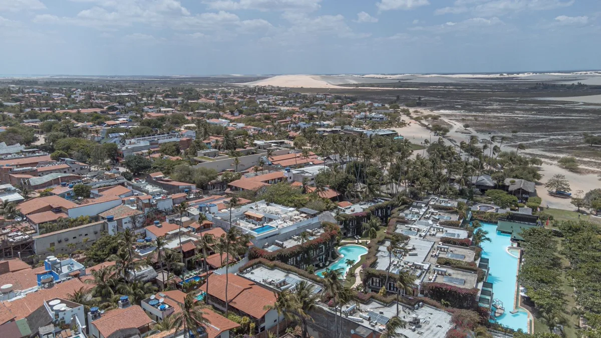 Vista aérea da Vila de Jericoacoara, com suas pousadas e dunas ao fundo